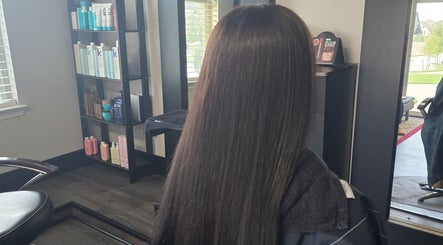 Long, straightened hair in Dreamcuts and Styles salon, Fulshear, Texas, US, with shelves of hair products.