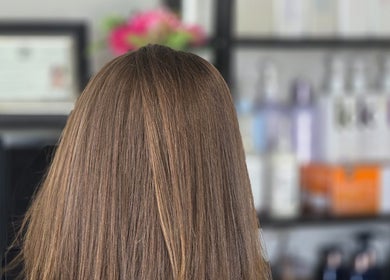 Shiny hair at Dreamcuts and Styles salon in Fulshear, Texas, US with products in the background.