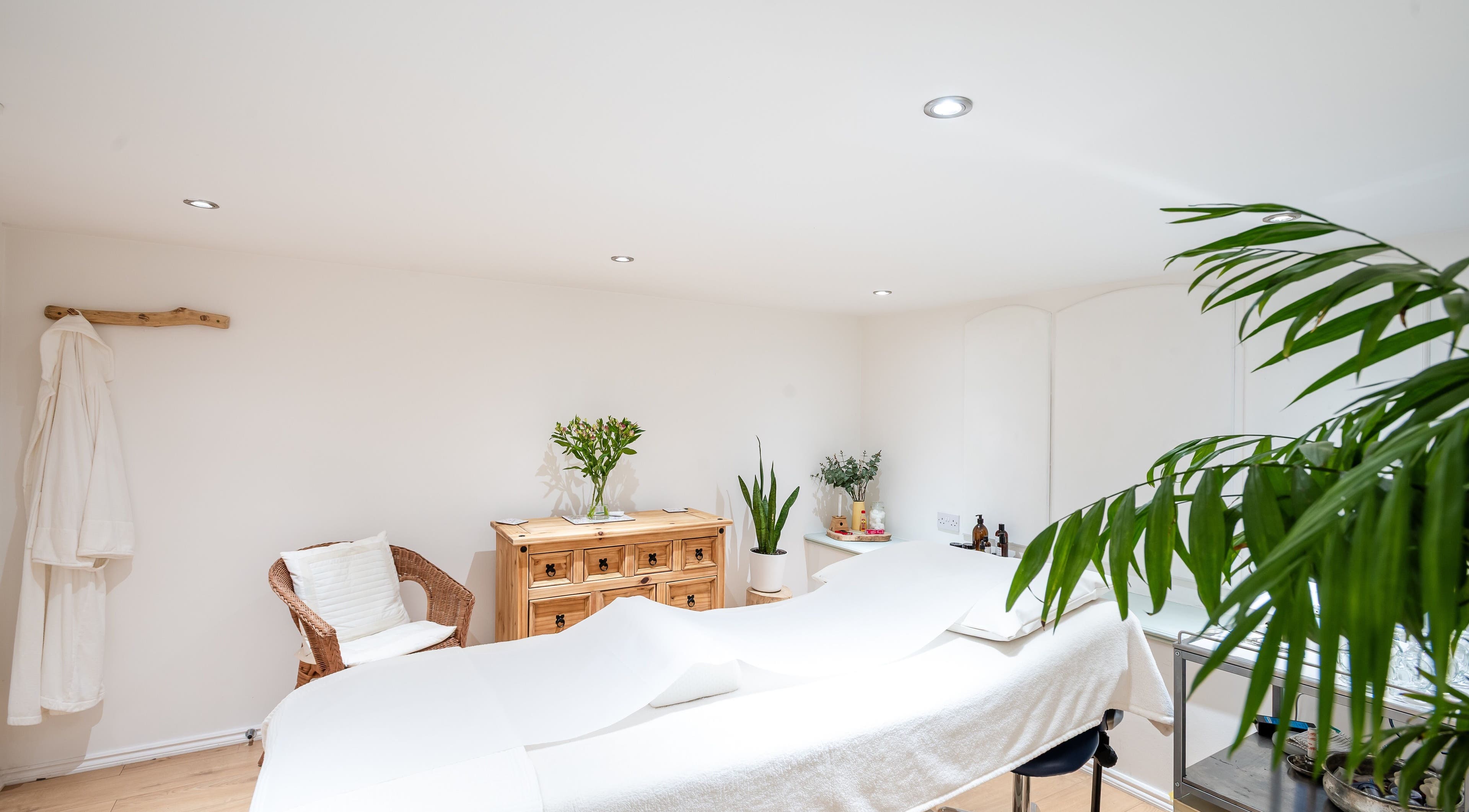 Tranquil treatment room at Nest Clinic, Urmston, England, GB with cozy decor and natural plants.