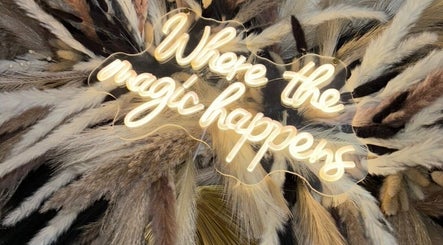 Illuminated sign 'Where the magic happens' at Luxe Cosmetics, Port Glasgow, Scotland, GB, adorned with pampas grass.