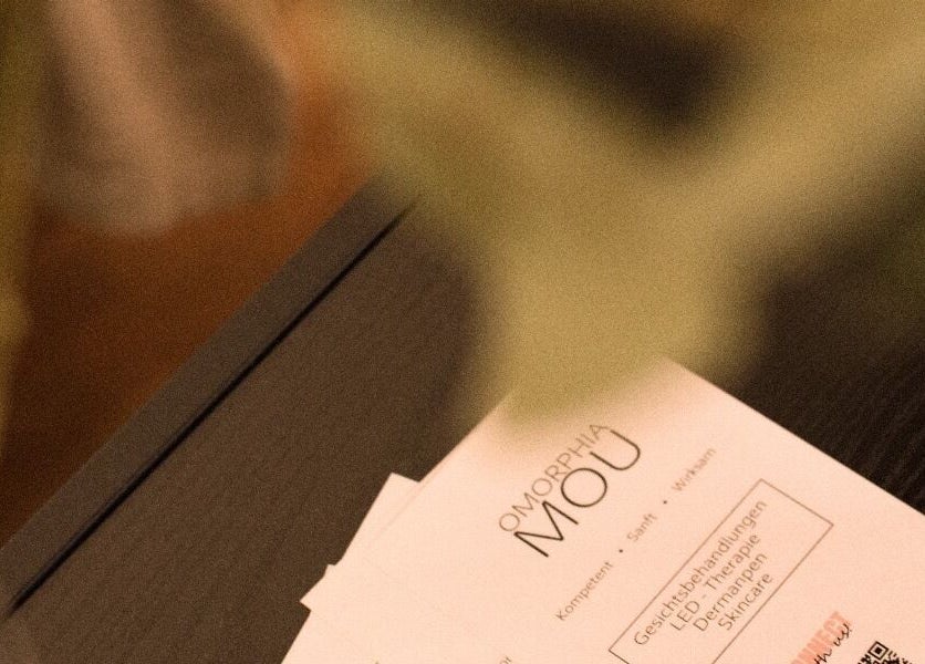 Flyer von Omorphia Mou in Karlsruhe, Baden-württemberg, DE auf einem Tisch, aufgenommen durch Pflanzen.