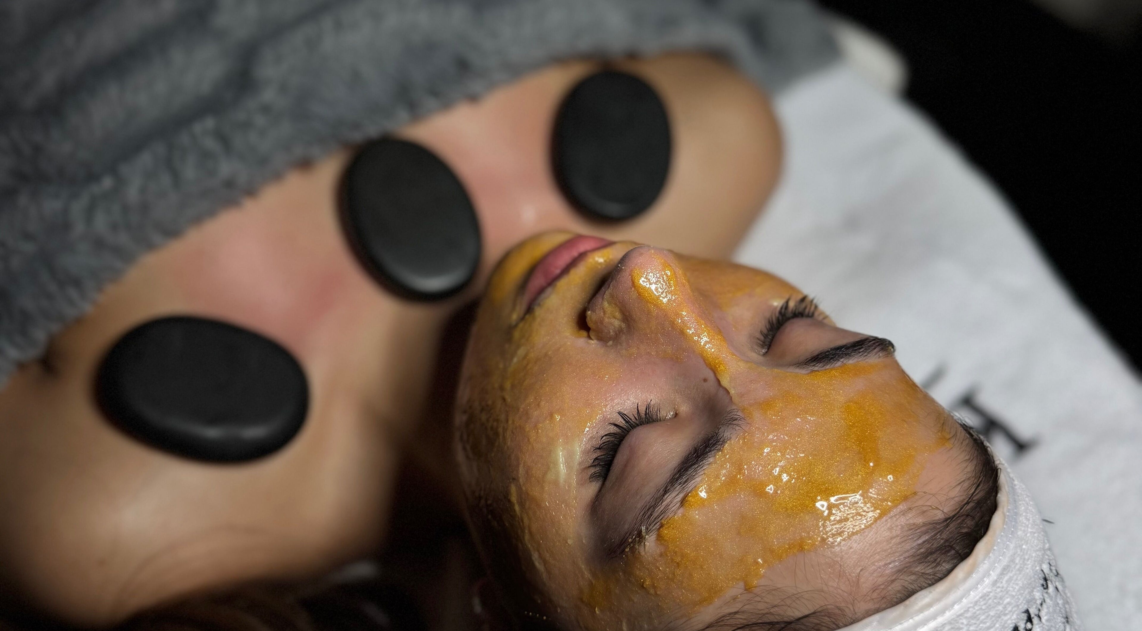 Relaxing facial treatment at Lini's Cosmetics in Vaughan, Ontario, CA with hot stones and golden mask.