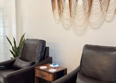 Relaxing leather chairs at Blissful Bay Spa with wall art in Mahone Bay, Nova Scotia, CA.