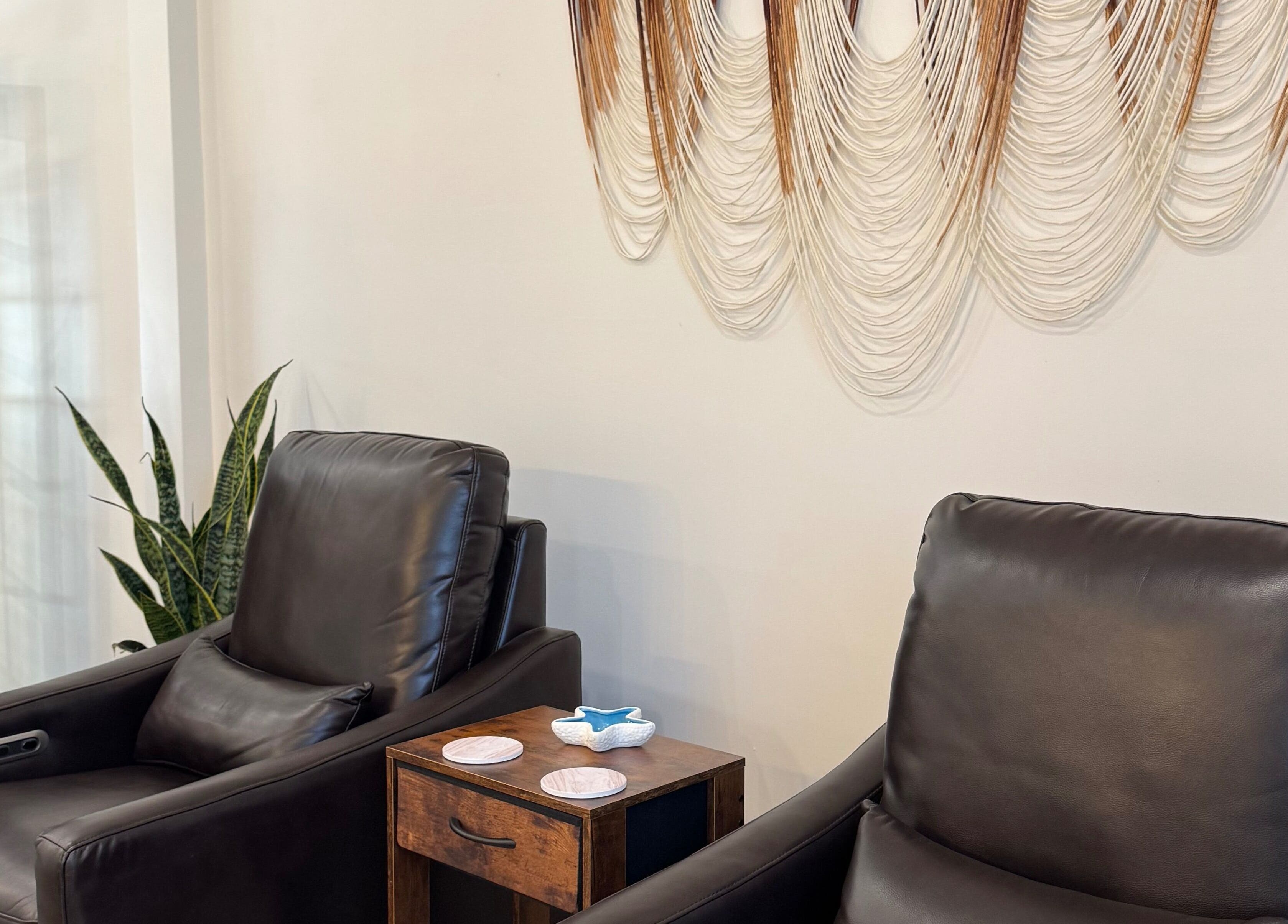 Relaxing leather chairs at Blissful Bay Spa with wall art in Mahone Bay, Nova Scotia, CA.