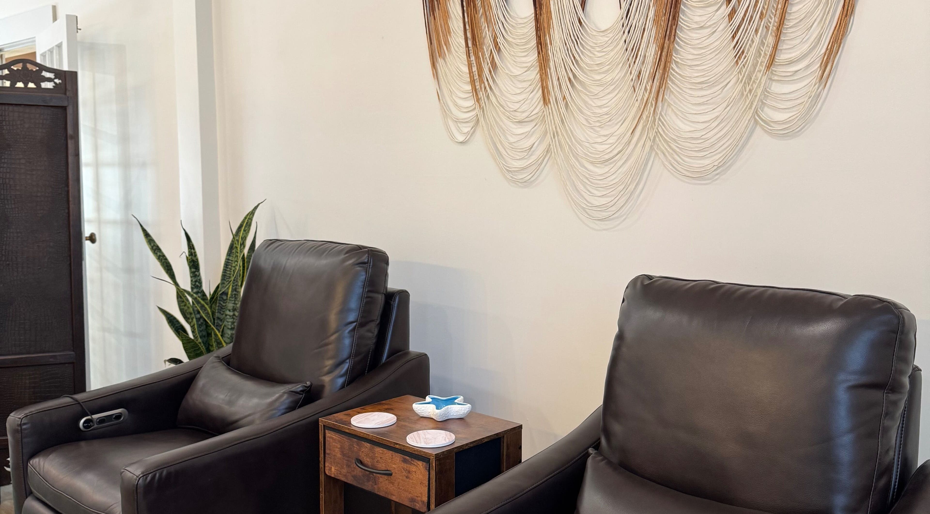 Relaxing leather chairs at Blissful Bay Spa with wall art in Mahone Bay, Nova Scotia, CA.