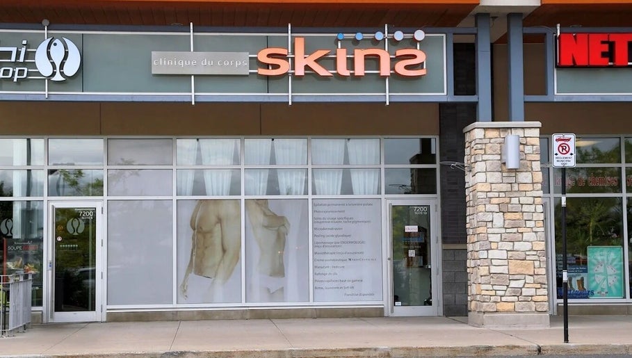Façade de Clinique Skins à Brossard, Québec, CA, avec enseignes modernes en vitrine.