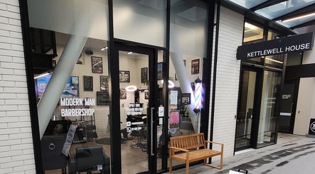 Entrance of Modern Man Barbershop in Christchurch, Canterbury Region, NZ with stylish interior visible.