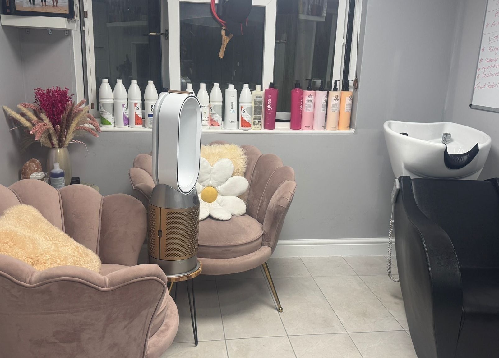 Cozy waiting area at Mila Hair Atelier in Epsom, England, GB, featuring plush chairs and elegant haircare products.