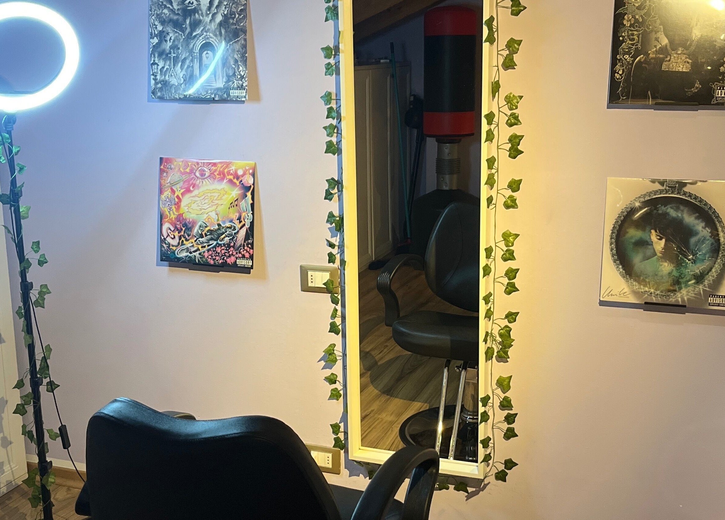Chic styling station at Barberstar in Feltre, Veneto, IT, featuring ivy-adorned mirror and artistic decor.