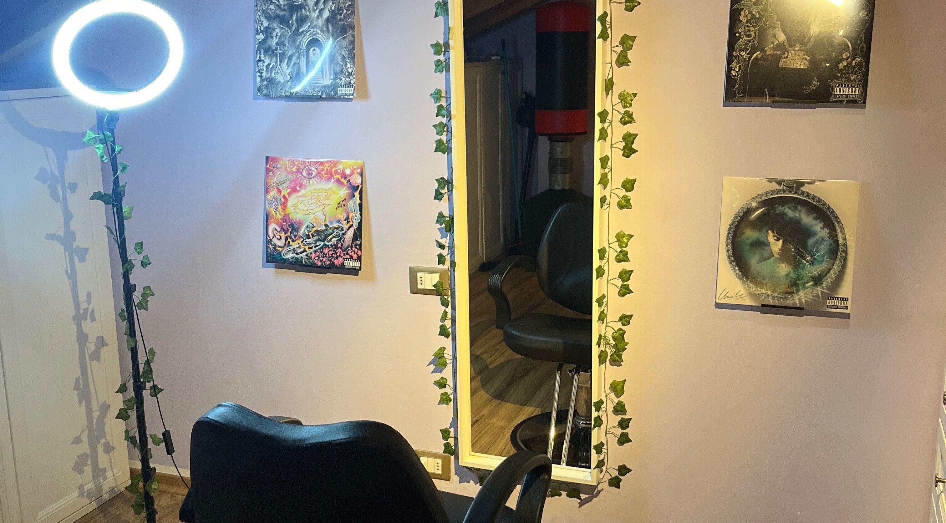 Chic styling station at Barberstar in Feltre, Veneto, IT, featuring ivy-adorned mirror and artistic decor.