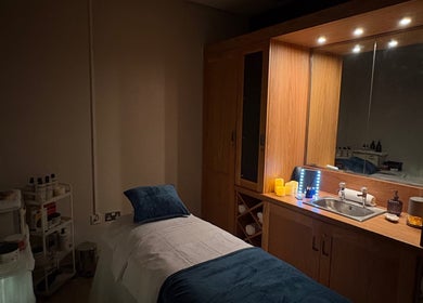 Cozy treatment room at Bay Sanctuary in Swansea, Wales, GB, featuring a massage bed and ambient lighting.