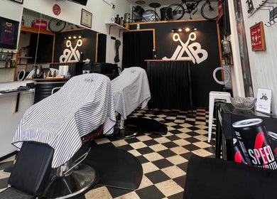Interior moderno de Jab Barber en Rosario, Santa Fe, AR, mostrando sillas de barbería y decoración elegante.