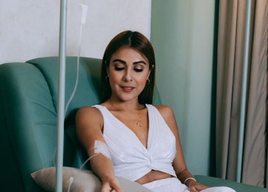 A woman enjoys an IV therapy session at LLERAS MEDICAL LOUNGE, Medellín, Antioquia, CO in a comfortable chair.