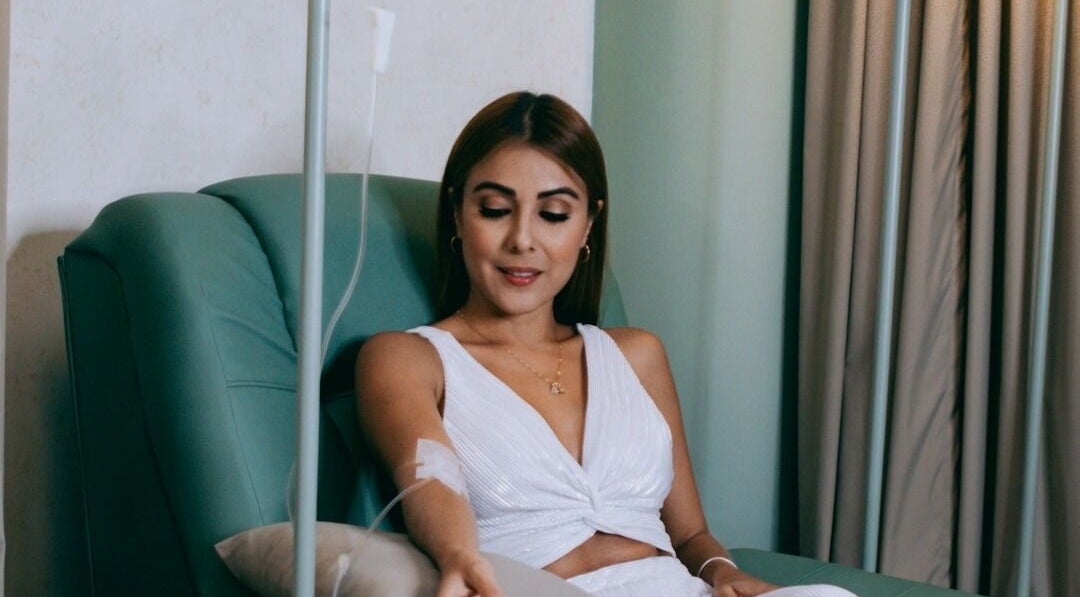 A woman enjoys an IV therapy session at LLERAS MEDICAL LOUNGE, Medellín, Antioquia, CO in a comfortable chair.