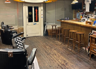 Interior of The Outro Barbershop, 서울특별시, KR, with vintage chairs and wooden bar area.