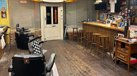Interior of The Outro Barbershop, 서울특별시, KR, with vintage chairs and wooden bar area.