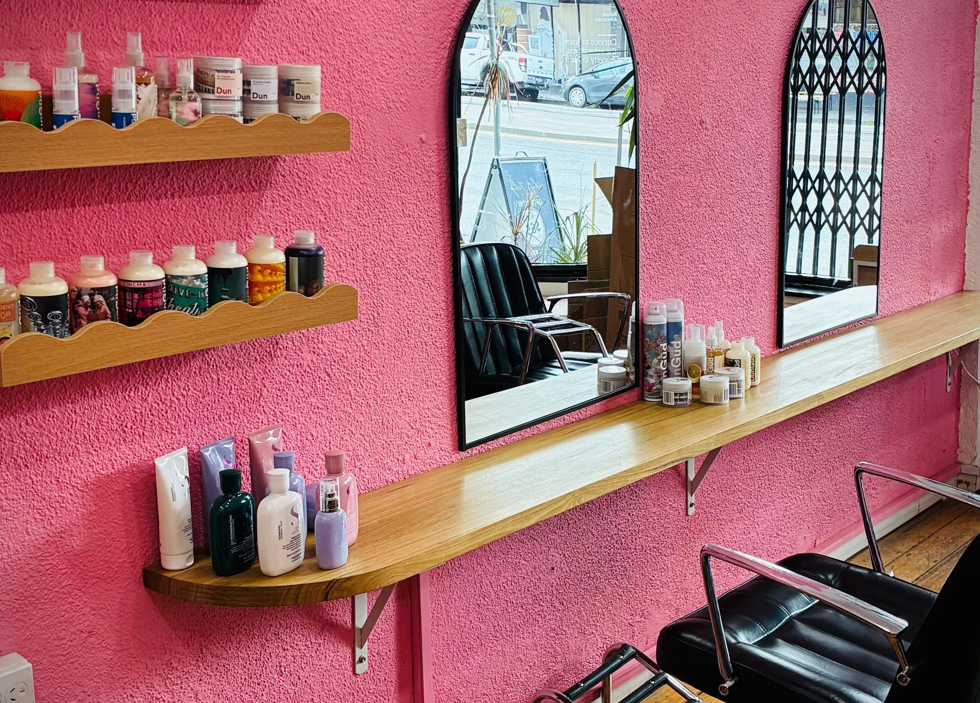 Stylish salon interior at Hair By Cat Scally, Melbourne, Victoria, AU with pink walls and modern decor.