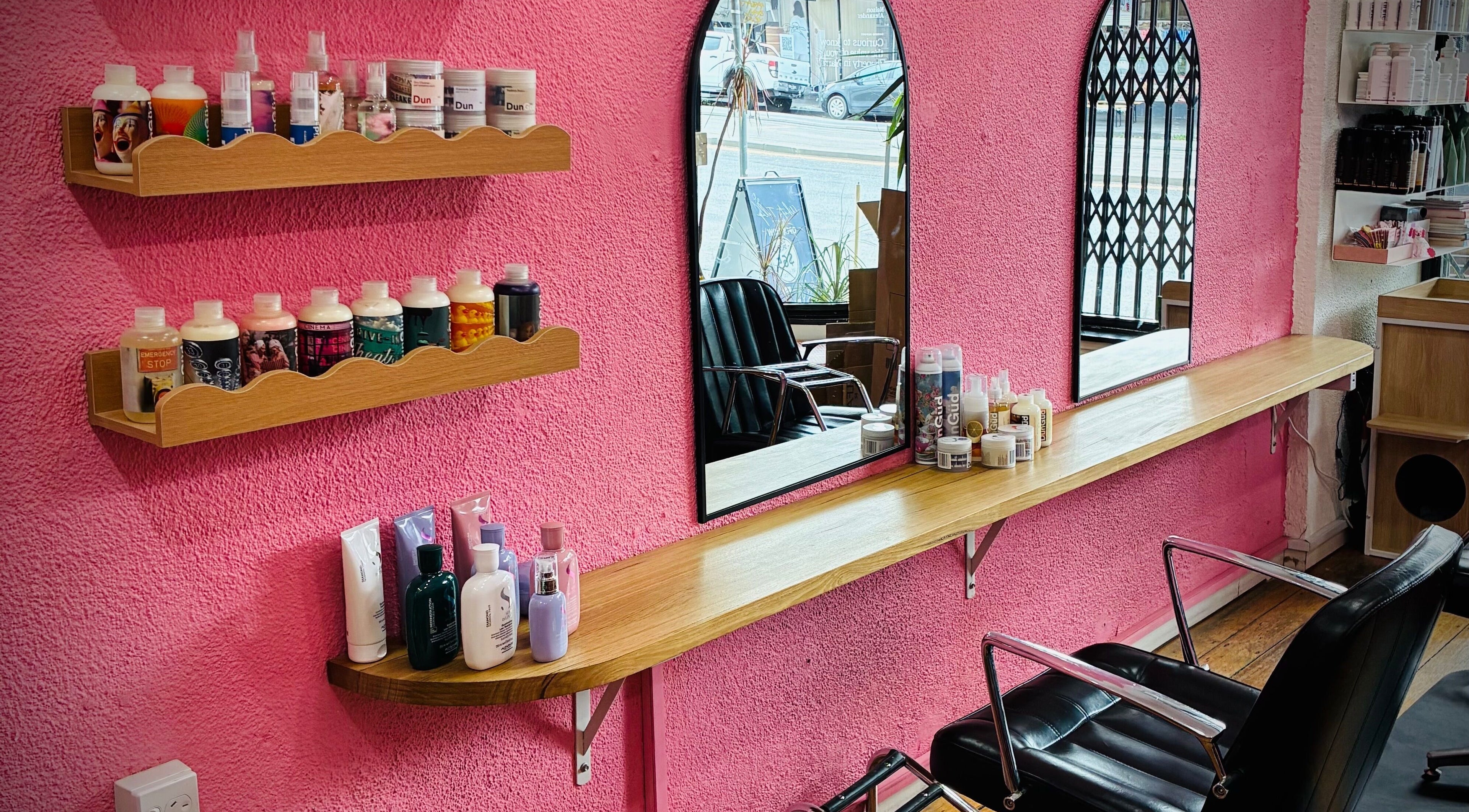 Stylish salon interior at Hair By Cat Scally, Melbourne, Victoria, AU with pink walls and modern decor.
