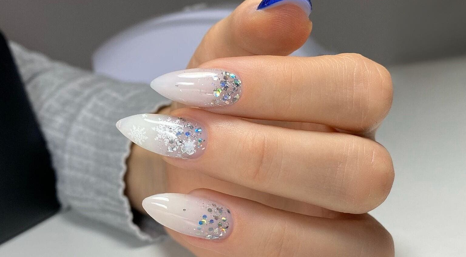 Glittering nail art design at MoJo Nails, Eden Prairie, Minnesota, US, showcasing snowflake and crystal details.