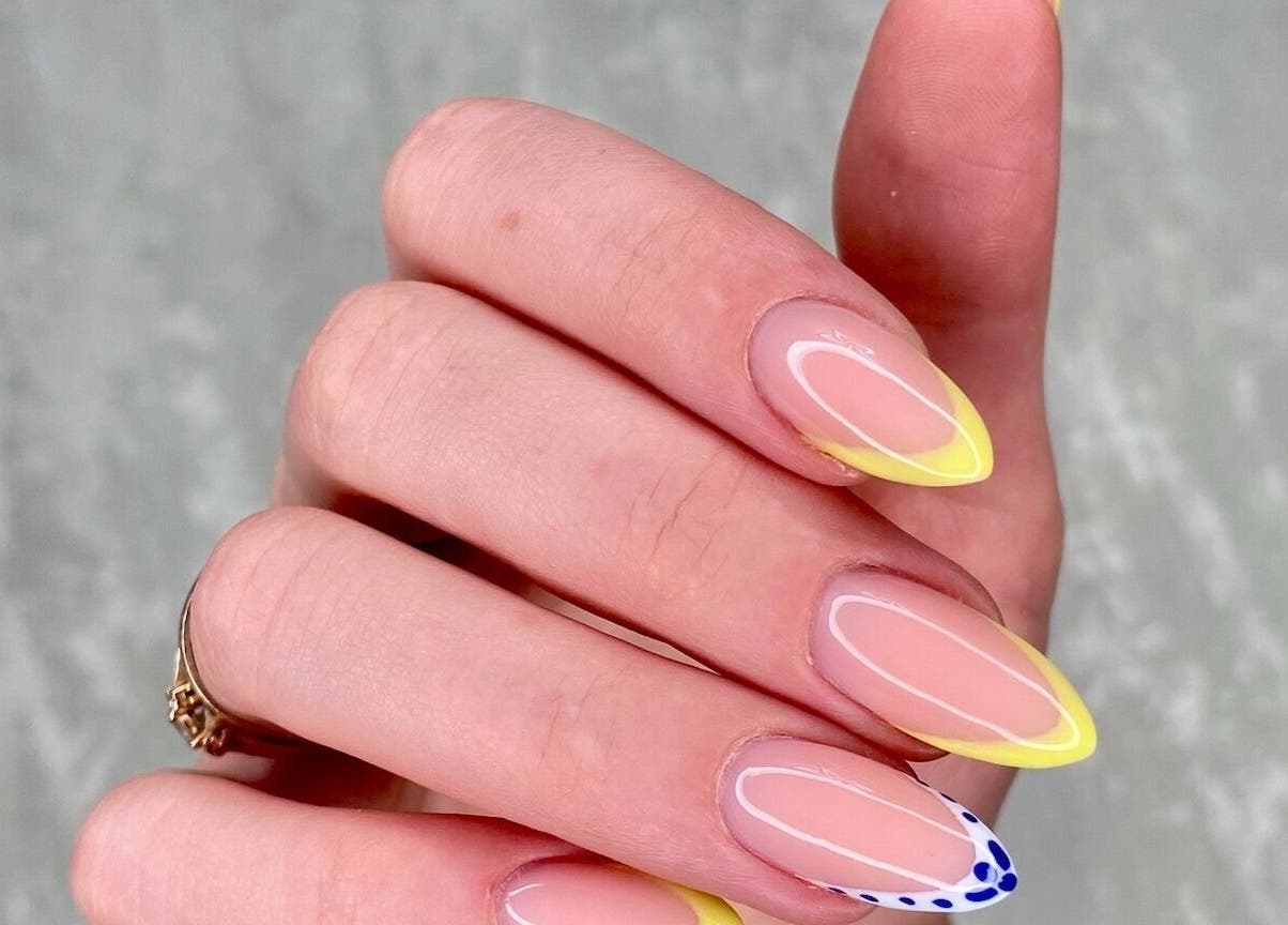 Yellow-tipped manicure with delicate design at MoJo Nails, Eden Prairie, Minnesota, US.