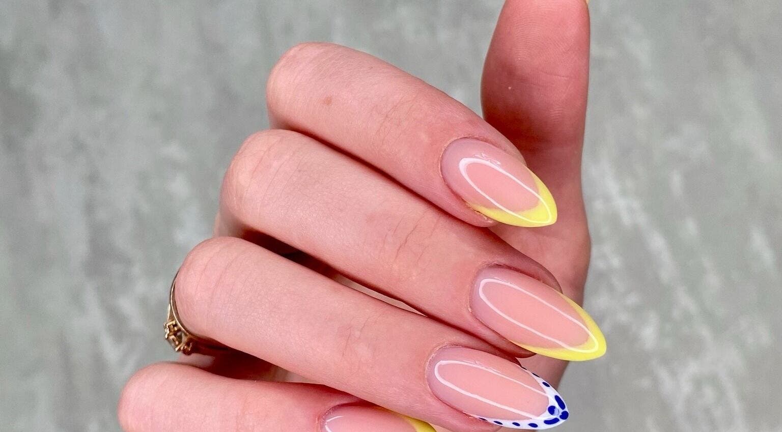Yellow-tipped manicure with delicate design at MoJo Nails, Eden Prairie, Minnesota, US.