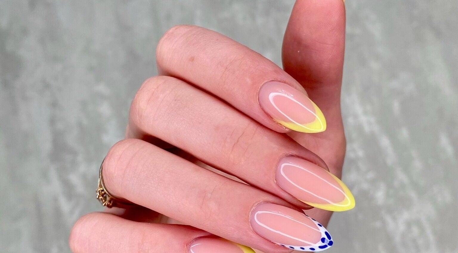 Yellow-tipped manicure with delicate design at MoJo Nails, Eden Prairie, Minnesota, US.