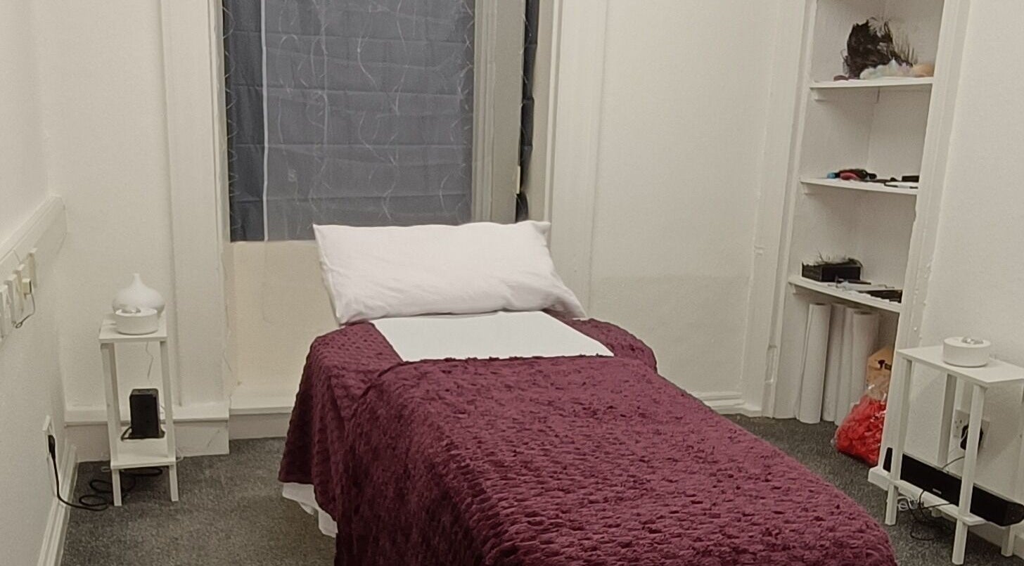 Peaceful massage room at Touch of Beauty ASMR Massage in Paisley, Scotland, GB with a cozy purple bedspread.