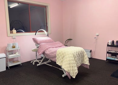 Relaxing treatment room at Goddess Glow Salon in Melbourne, Victoria, AU with pink decor and reclining bed.