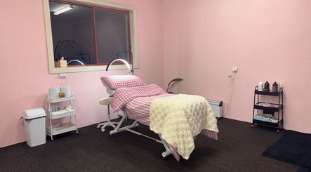 Relaxing treatment room at Goddess Glow Salon in Melbourne, Victoria, AU with pink decor and reclining bed.