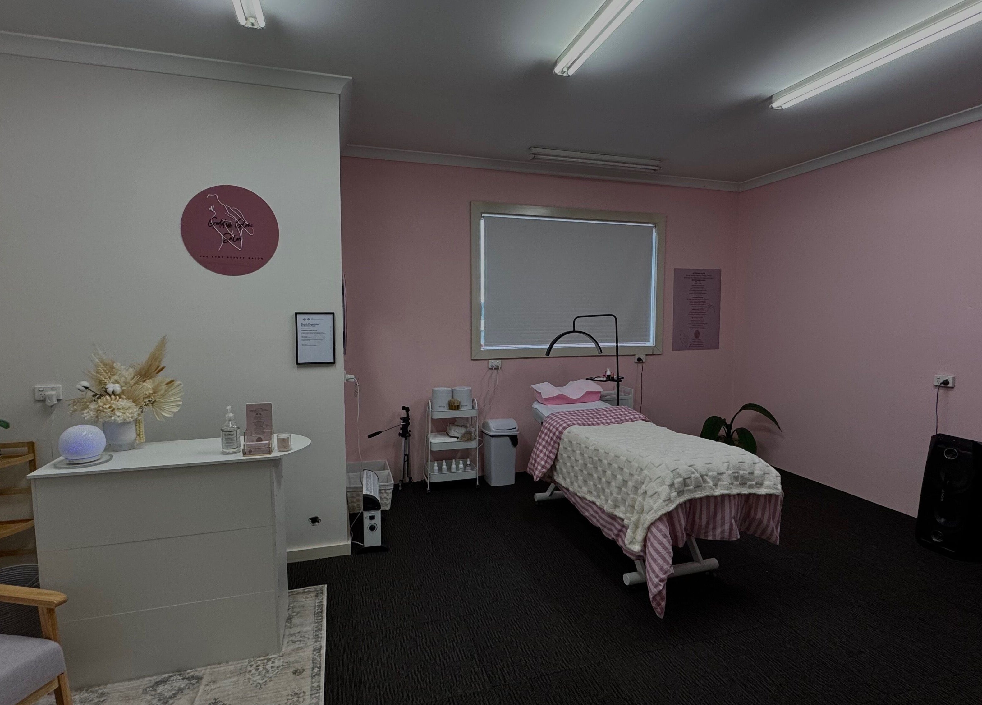 Tranquil therapy room at Goddess Glow Salon in Melbourne, Victoria, AU with pink walls and a cozy treatment bed.