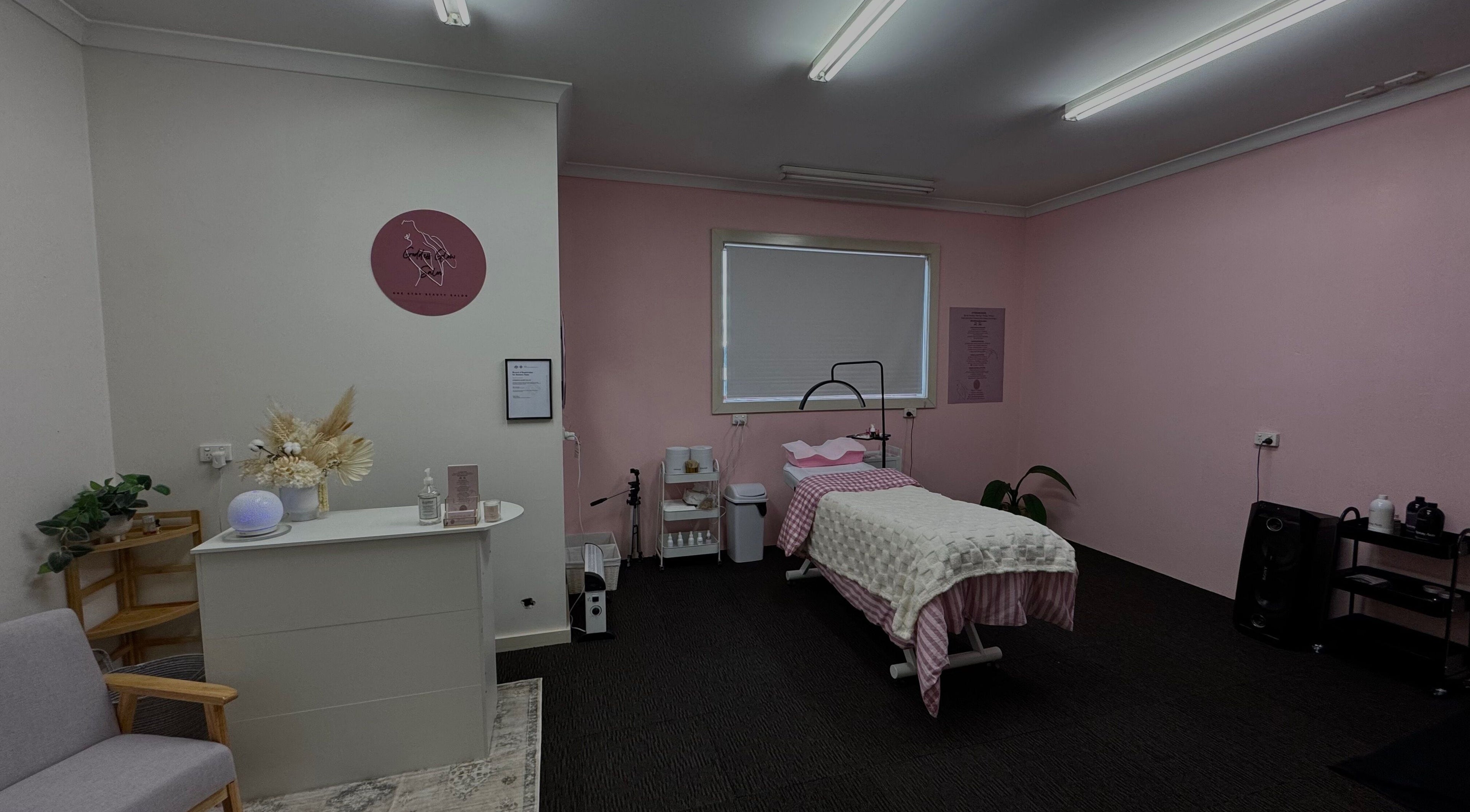 Tranquil therapy room at Goddess Glow Salon in Melbourne, Victoria, AU with pink walls and a cozy treatment bed.