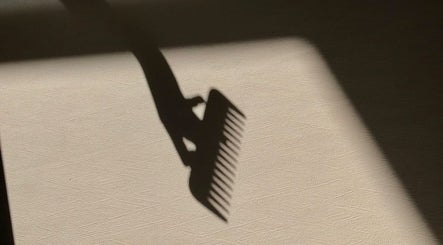 Shadow of a comb on textured surface at MaddyLox, Toronto, Ontario, CA, exemplifying elegance and style.