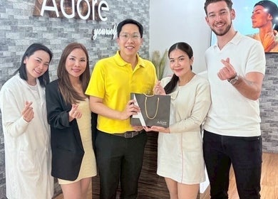 Adore Cosmetics team in Krung Thep Maha Nakhon, TH, poses happily with a branded bag.
