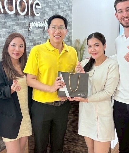 Adore Cosmetics team in Krung Thep Maha Nakhon, TH, poses happily with a branded bag.
