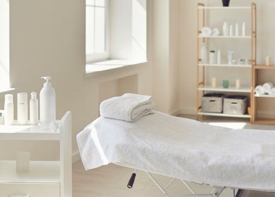 Behandlungsraum bei Perfect Skin in Bonn, Nordrhein-Westfalen mit Massagebett und Pflegeprodukten.