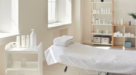 Behandlungsraum bei Perfect Skin in Bonn, Nordrhein-Westfalen mit Massagebett und Pflegeprodukten.