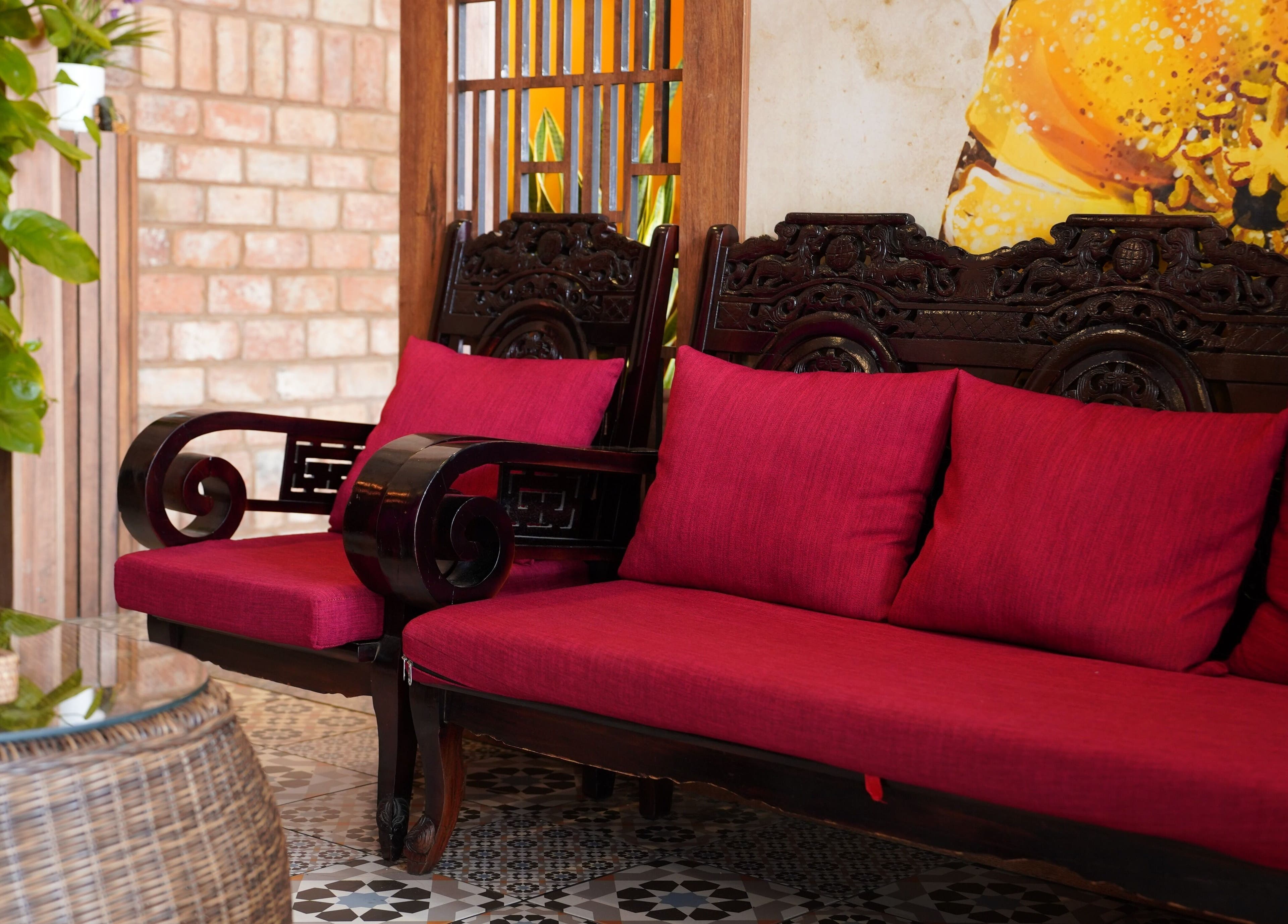 Ghế gỗ với đệm đỏ tại Panda Spa, Đà Nẵng, Đà Nẵng, VN, tạo không gian thư giãn ấm cúng.