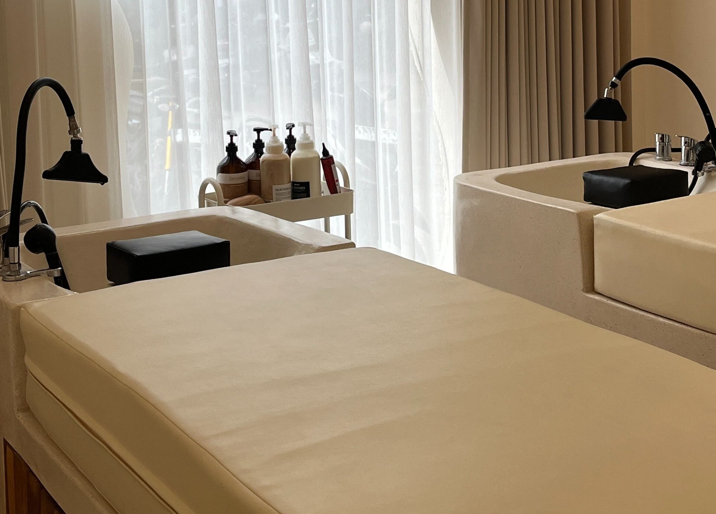 Relaxing treatment area at The Pause Hair Salon and Head Spa, Bali, Bali, ID. Comfortable spa beds and pristine sinks.