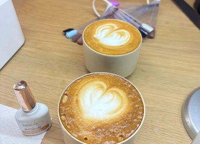 Heart-patterned lattes on a table at Angel Nails, Uccle, Bruxelles, BE, adding charm to your beauty experience.