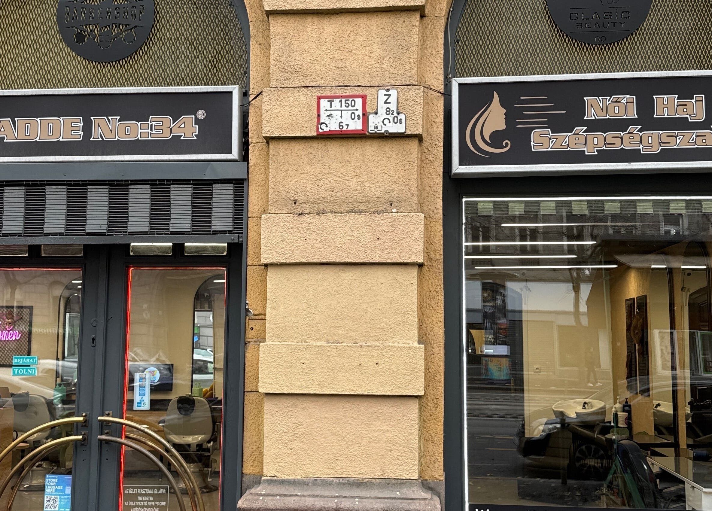 Entrance of CADDE34hair salon in Budapest, Magyar, HU, showcasing elegant design and inviting glass doors.