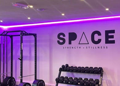 Modern gym setup at Amy Pickett Fitness in Sawbridgeworth, England, GB with weights and vibrant lighting.
