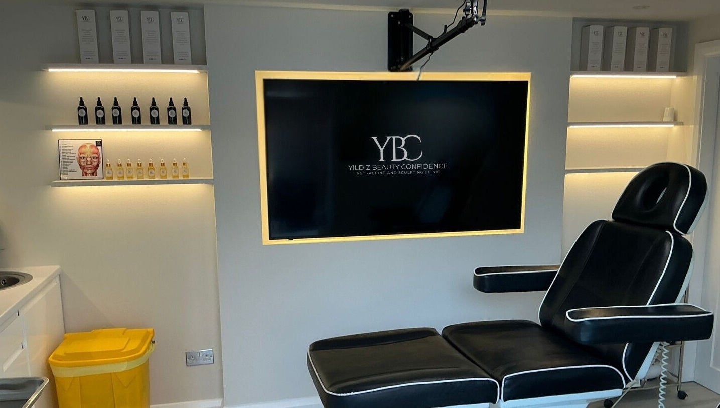 Modern treatment room at Yildiz Beauty Confidence, Loughton, England, GB with sleek chair and illuminated shelves.