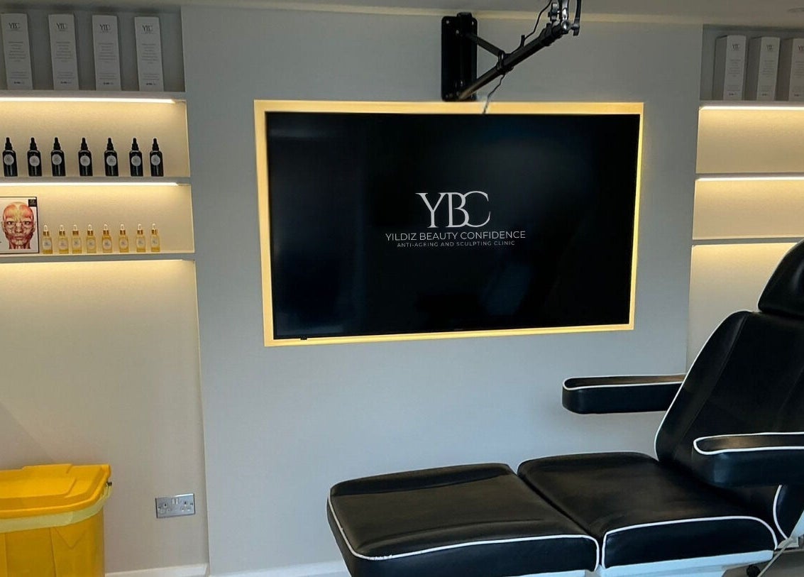 Modern treatment room at Yildiz Beauty Confidence, Loughton, England, GB with sleek chair and illuminated shelves.
