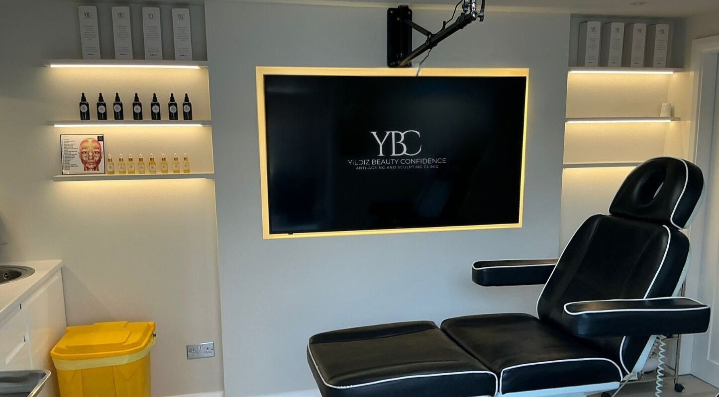 Modern treatment room at Yildiz Beauty Confidence, Loughton, England, GB with sleek chair and illuminated shelves.
