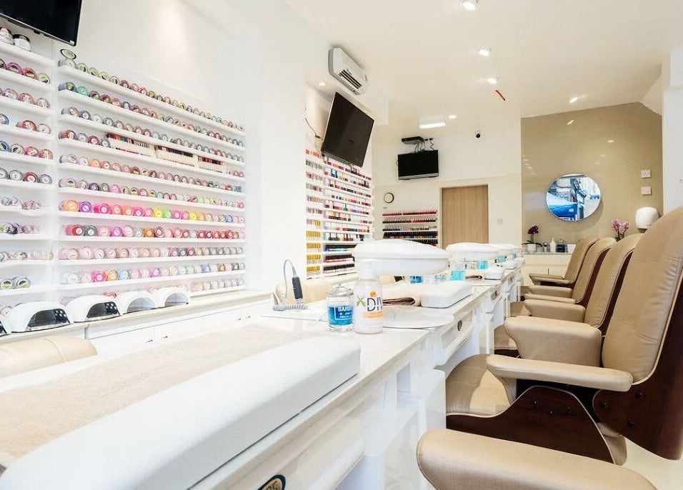 Interior of Diva Star Nails, London, England, GB, showcasing manicure tables and colorful polish display.