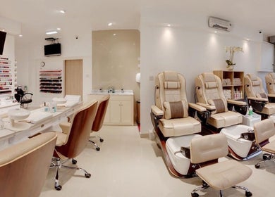 Luxurious interior of Diva Star Nails in London, England, GB showcasing plush pedicure chairs and nail polish wall.