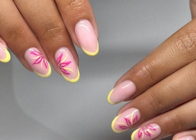 Stylish nail art with pink floral design and yellow tips at NAIL’D IT by khushi, Leicester, England, GB.