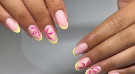 Stylish nail art with pink floral design and yellow tips at NAIL’D IT by khushi, Leicester, England, GB.
