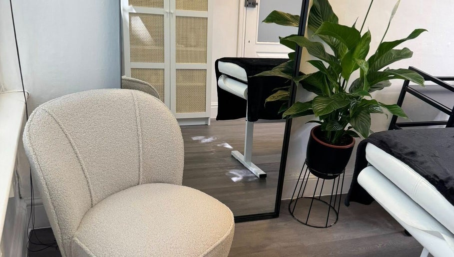 Serene interior at The Skiiin Nutritionist, Bristol, England, featuring plush chair and lush plant.