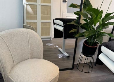 Serene interior at The Skiiin Nutritionist, Bristol, England, featuring plush chair and lush plant.